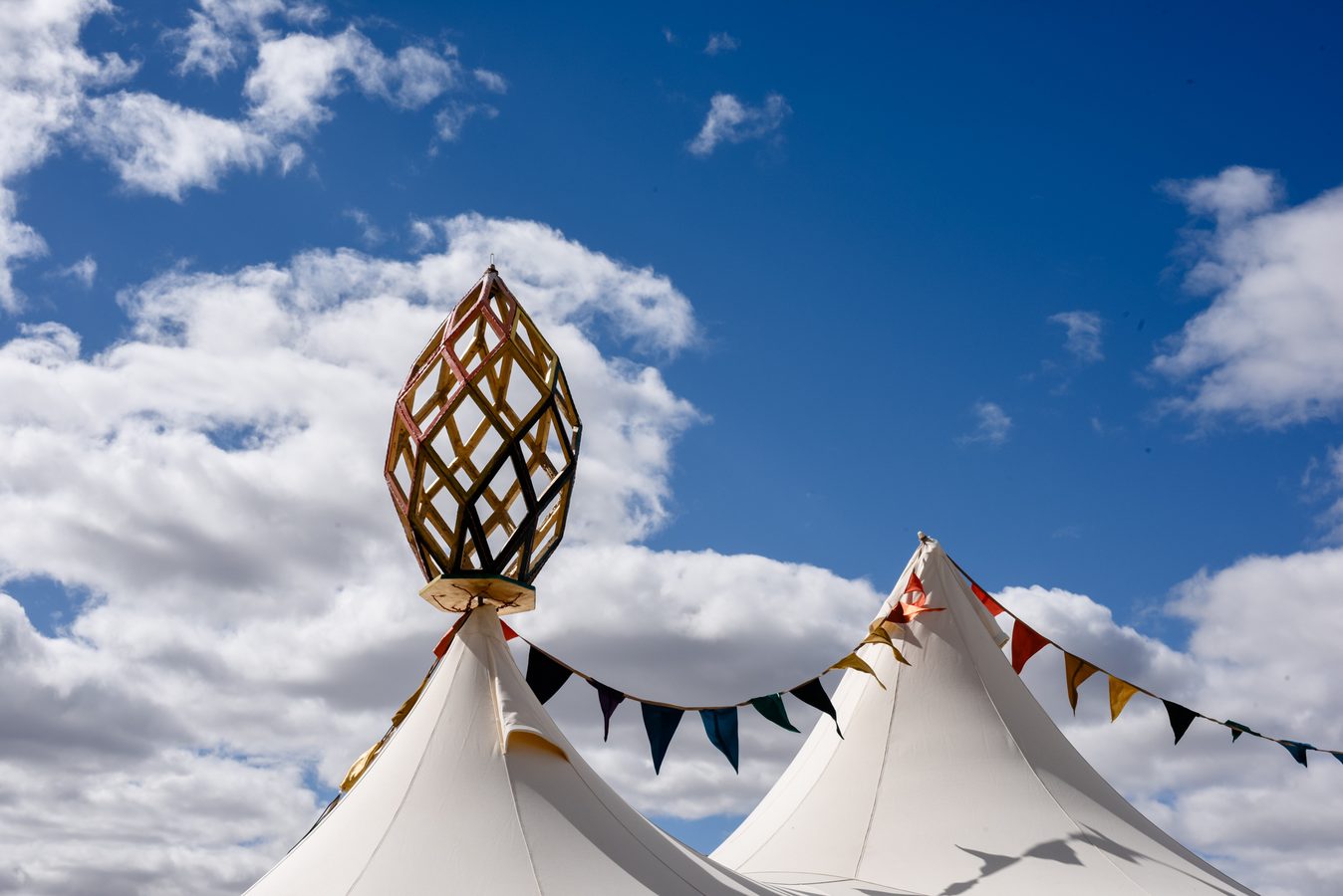 The golden finial on top of the Lotus Mahal, with bunting, against a blue sky