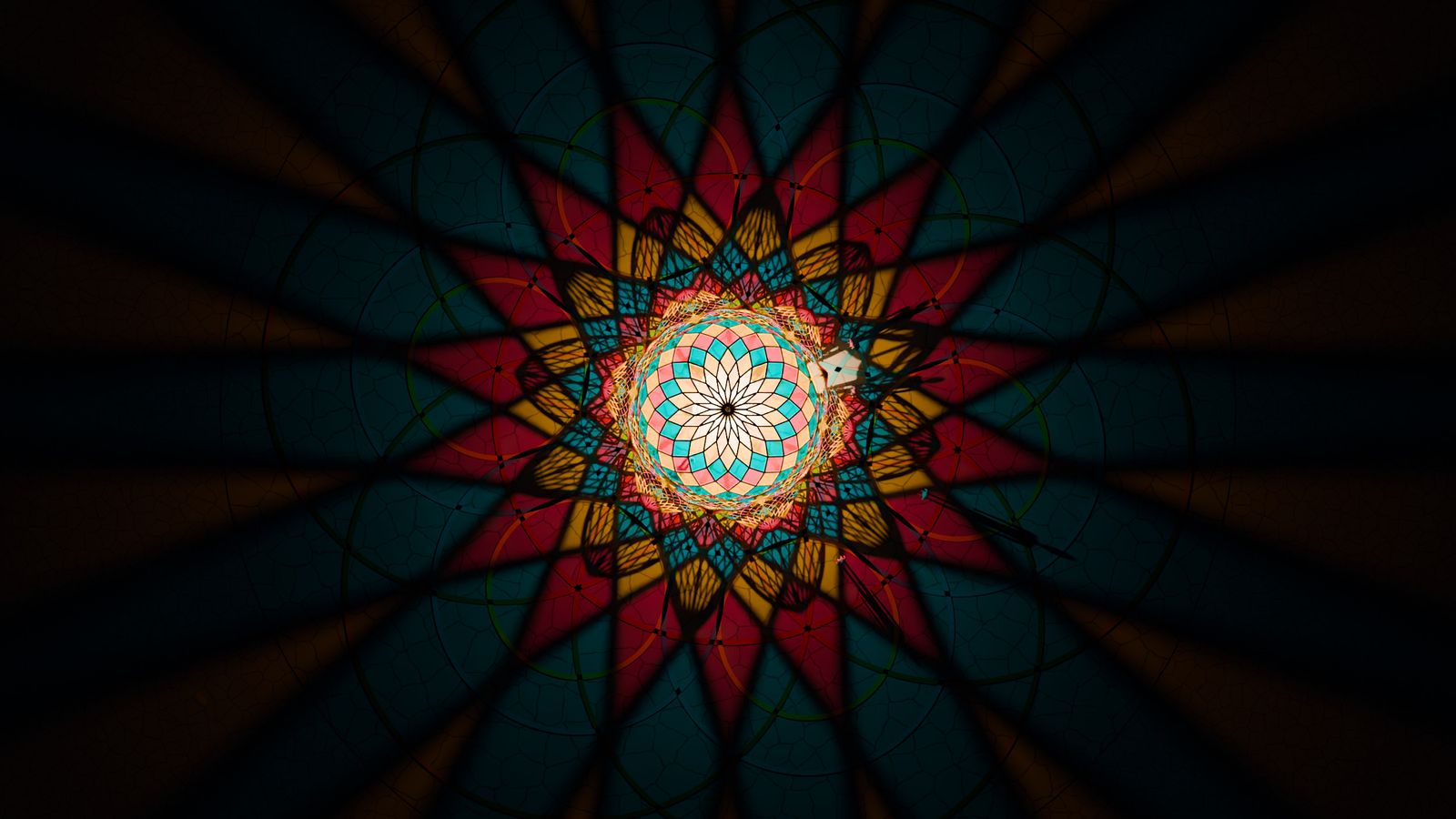 The Seed from directly above at night: the lit dome like a rose window, a star of coloured light spreading across the clay